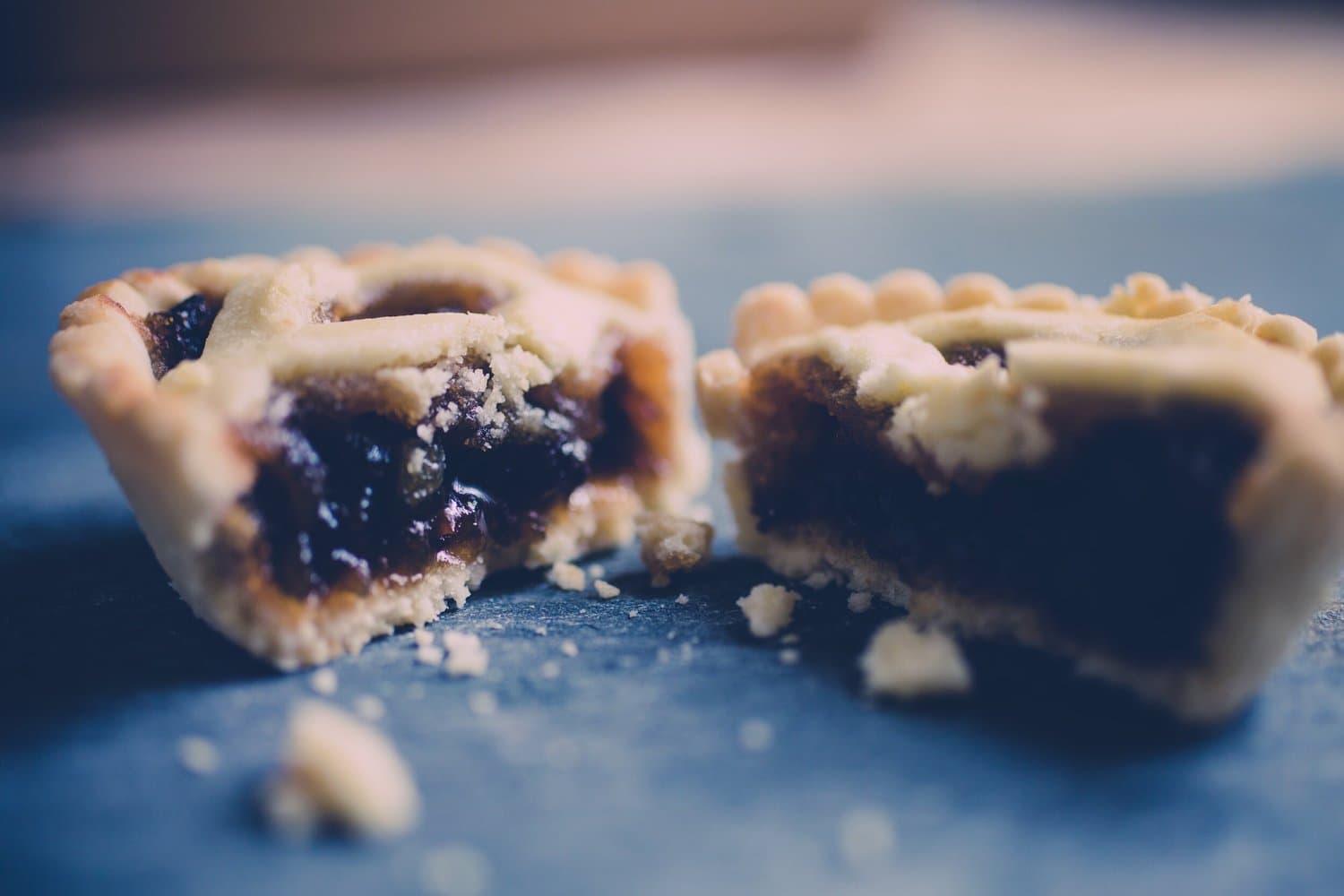 Mince pies on a plate, one of them broken open